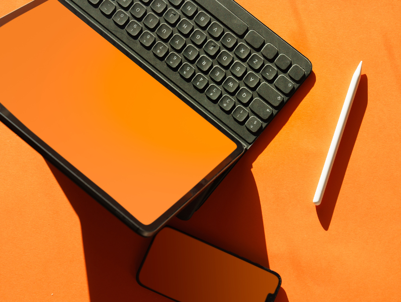 Tablet, touchstift und Handy auf Bunten Tisch.