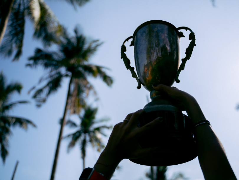 Preispokal wird in der Luft gehalten durch zwei Hände.