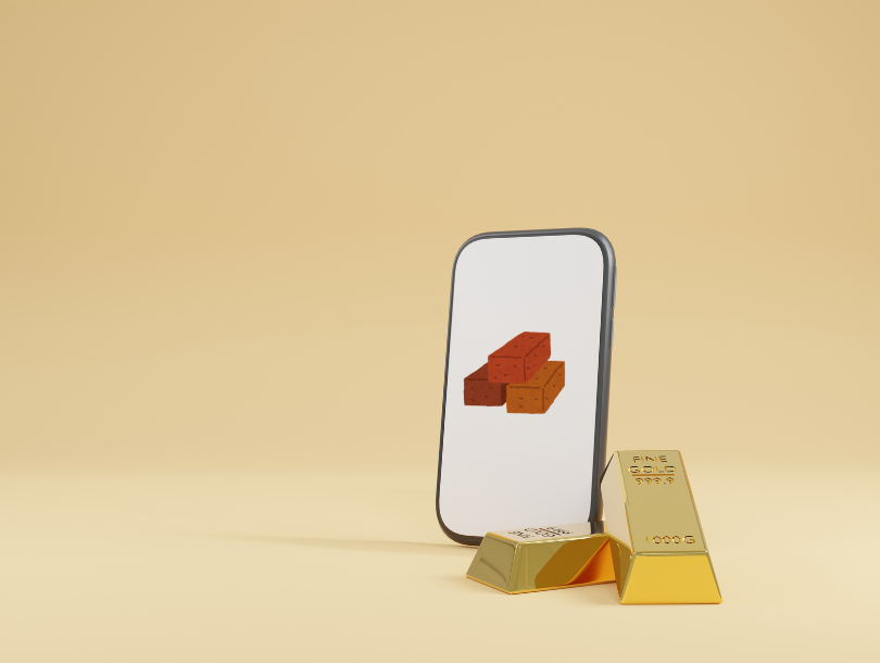 Ein Handy mit drei Ziegelsteine, und neben das Handy zwei Goldbars