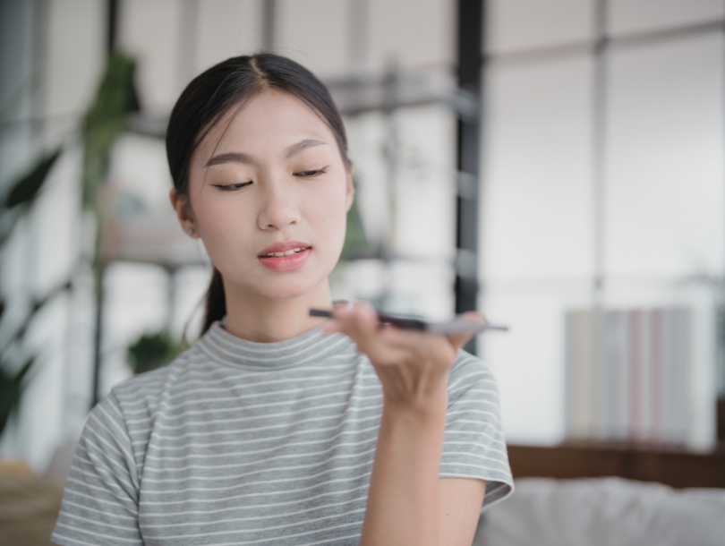 Mensch hat Handy in der Hand und spricht mit das Handy auf lautsprecher