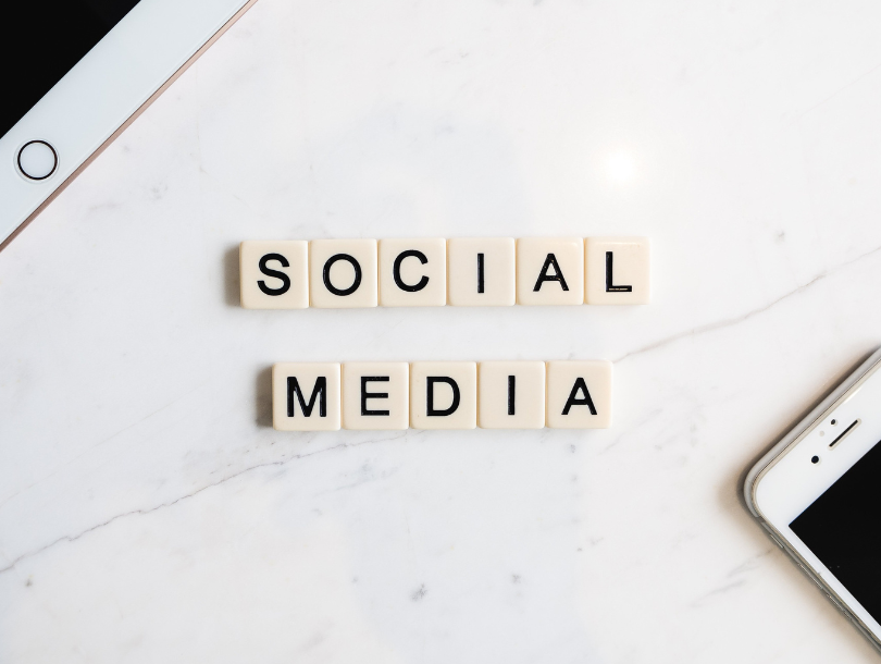 Hand und Tablet auf Marmor Tisch. Mit Scrabble Spielsteine ist SOCIAL MEDIA Geschrieben.